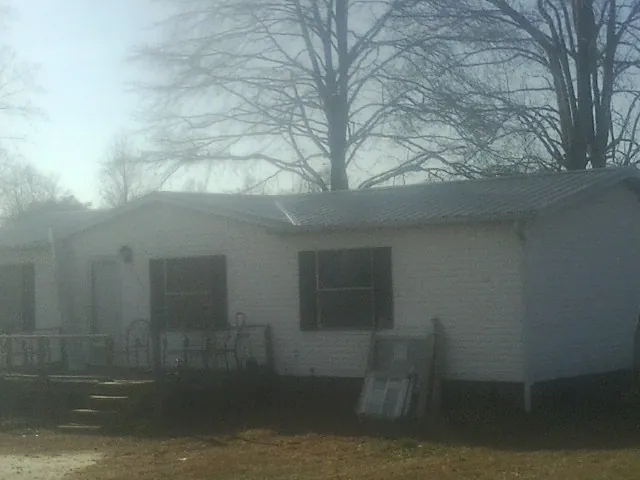 New metal roof on a white painted brick home on a foggy morning in Scio