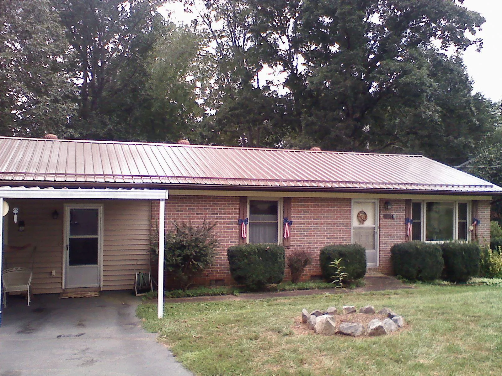 Bronze metal roof and carport on a brick ranch home — Roof Repair work by our crew in Scio